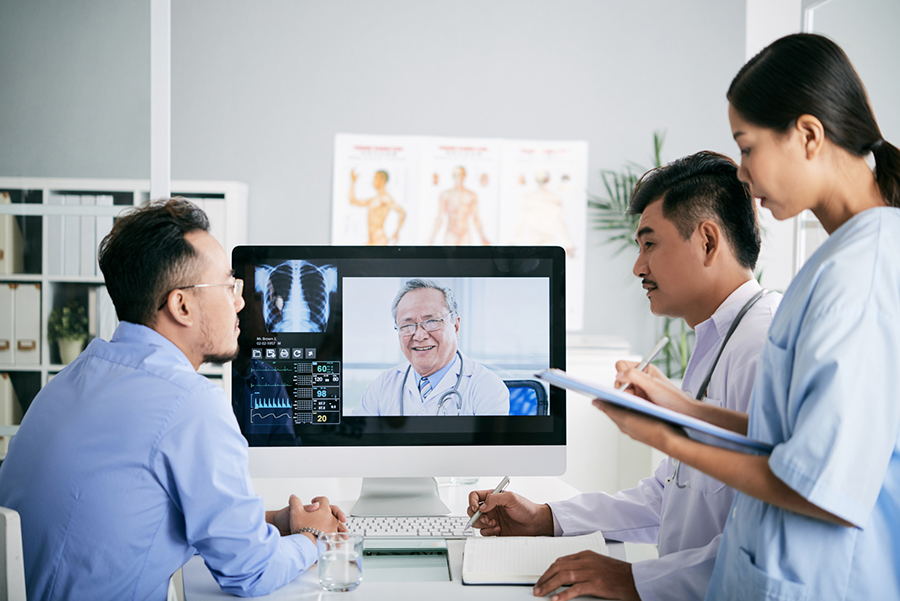 Asian medical interns consullting with doctor online